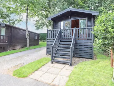 a wooden cabin with a staircase leading to a door at Ennerdale Lodge in Keswick