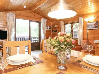 a dining room with a table with flowers on it at Ennerdale Lodge in Keswick