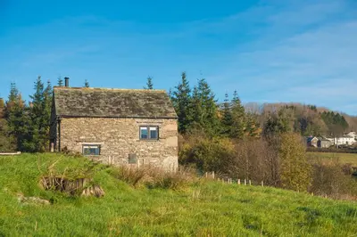 an old stone house on a hill in a field at The Hidden Place in Penrith