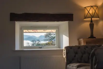 a window in a room with a couch and a lamp at The Hidden Place in Penrith