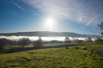 a green field with the sun in the sky at The Hidden Place in Penrith