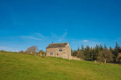 an old stone house on a hill in a field at The Hidden Place in Penrith
