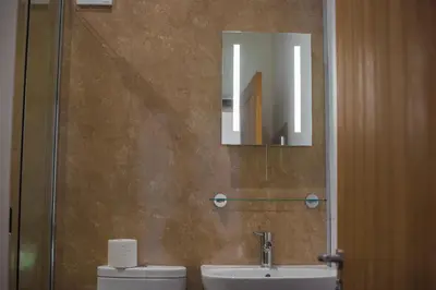 a bathroom with a toilet and a sink and a mirror at The Hidden Place in Penrith