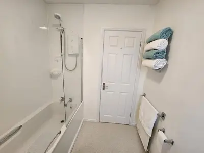 a bathroom with a shower and a toilet and towels at 10 Ladyknowe court in Moffat