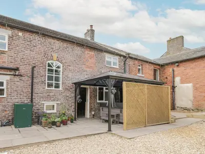 a brick building with a black canopy in front of it at The Hollies in Carlisle