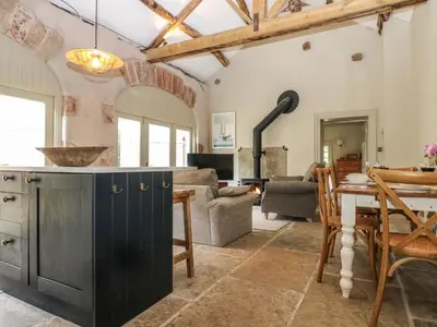 a kitchen and living room with a table and chairs at The Courtyard in Carlisle
