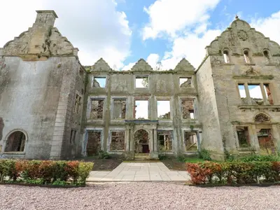 an old stone building with flowers in front of it at The Courtyard in Carlisle