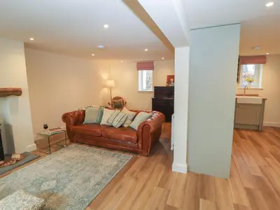 a living room with a brown leather couch at Cobble Cottage in Keswick