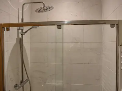 a shower in a bathroom with a glass door at Striding Edge Cottage in Glenridding