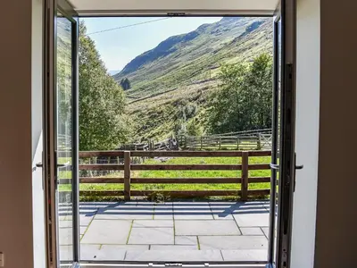 an open door with a view of a mountain at Striding Edge Cottage in Glenridding