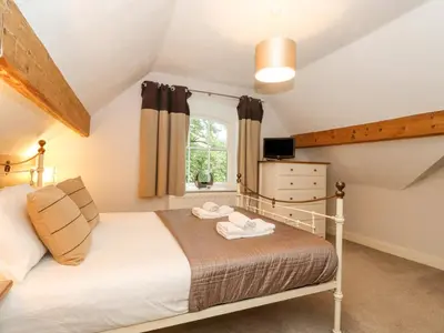 a bedroom with a bed and a window at Riverbank in Ambleside