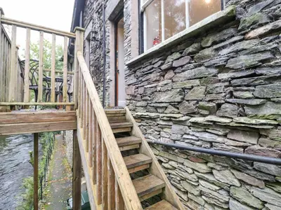a wooden staircase leading up to a stone building at Riverbank in Ambleside