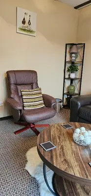 a living room with a leather chair and a table at Ash Cottage in Stranraer