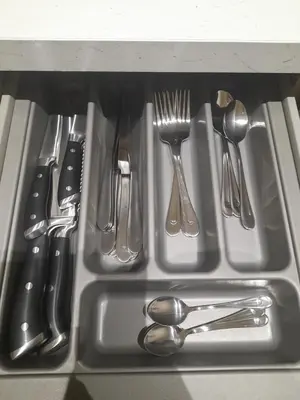 a sink with silver utensils in a drawer at Kirkcudbright Holiday Apartments - Apartment D in Kirkcudbright