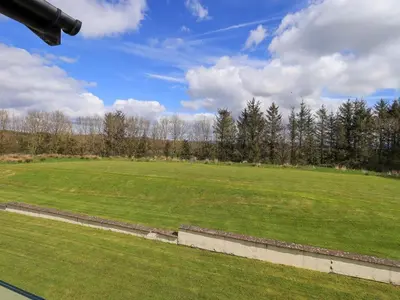 a large green field with trees in the background at Mallard Cottage Lake District, Leisure Spa Pool & Gym in Penruddock