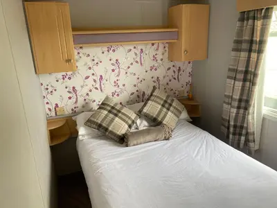 a bed with two pillows on it in a bedroom at Inglenook Caravan in Lamplugh