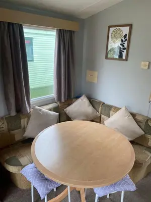 a living room with a table and a couch at Inglenook Caravan in Lamplugh