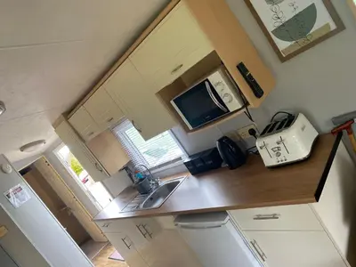 a small kitchen with a sink and a microwave at Inglenook Caravan in Lamplugh
