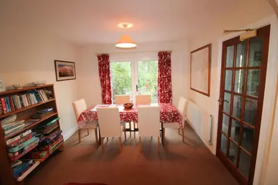 a dining room with a table and chairs and a window at Hill Cottage, Braithwaite with garden and fell views, dog friendly walks from the door, close to Bassenthwaite in Braithwaite