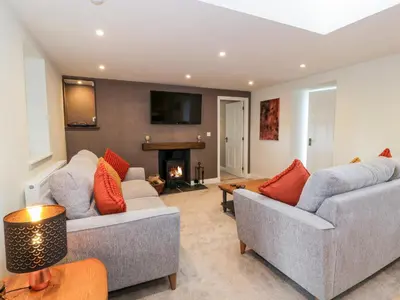 a living room with two couches and a fireplace at Hardhills Cottage in Castle Douglas