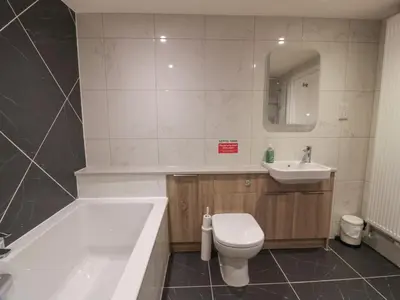a bathroom with a tub and a toilet and a sink at Hardhills Cottage in Castle Douglas