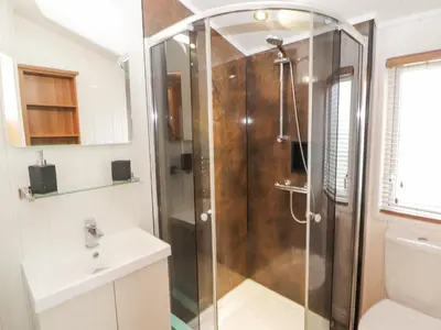 a shower with a glass door in a bathroom at No 7 Skiddaw View in Cockermouth