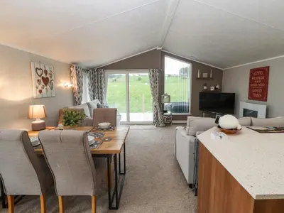 a living room with a table and chairs and a couch at No 7 Skiddaw View in Cockermouth