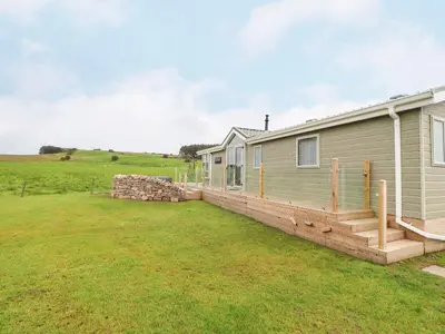 a home with a large yard next to a house at No 7 Skiddaw View in Cockermouth