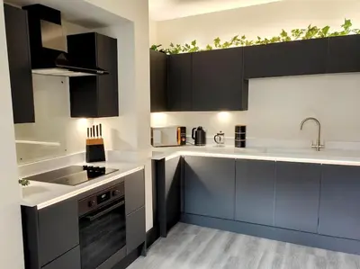 a kitchen with black and white cabinets and a sink at Carvetii - ANNE House Room 2 - Dbl bed First floor en-suite in Carlisle