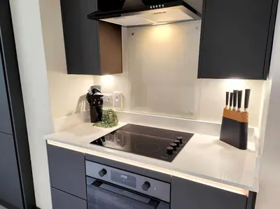 a kitchen with black cabinets and a stove top oven at Carvetii - ANNE House Room 2 - Dbl bed First floor en-suite in Carlisle