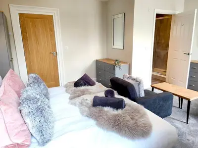 a bedroom with a bed with fur pillows on it at Carvetii - ANNE House Room 3 - Triple bed first flr en-suite in Carlisle