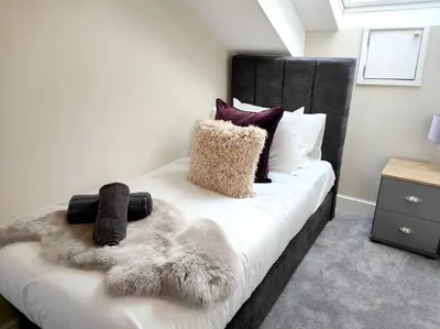 a bedroom with a white bed with a black headboard at Carvetii - ANNE House Room 4 - Triple bed 2nd floor en-suite in Carlisle