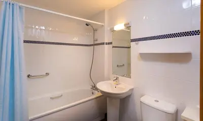 a bathroom with a sink and a toilet and a shower at Keswick Bridge Lodge Resort in Keswick