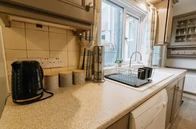 a kitchen with a sink and a counter top at Winnie's Cottage - 3 Bed Accommodation in Cumbria in Mealsgate