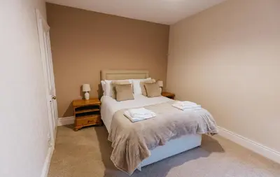 a bedroom with a bed with towels on it at Winnie's Cottage - 3 Bed Accommodation in Cumbria in Mealsgate