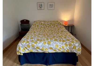 a bedroom with a bed with a yellow and white bedspread at Willow Cottage, Gilchristland Organic Farm in Closeburn