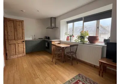 a kitchen with a table and chairs and a window at Willow Cottage, Gilchristland Organic Farm in Closeburn