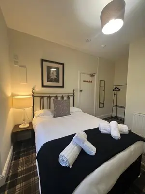 a bedroom with a large bed with towels on it at Elizabeth Grace House in Douglas