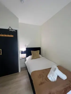 a bedroom with a bed with a towel on it at Elizabeth Grace House in Douglas