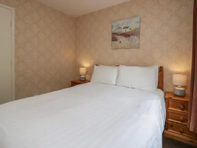 a bedroom with a large white bed with two night stands at Apartment 4 in Keswick