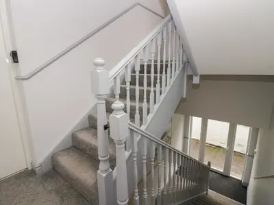a staircase with white railings in a house at Apartment 1 in Keswick