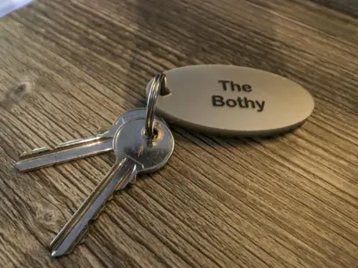 a pair of keys sitting on a wooden table at The Bothy in Keswick