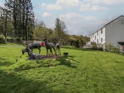 a group of deer statues in a grassy field at The Bothy in Keswick