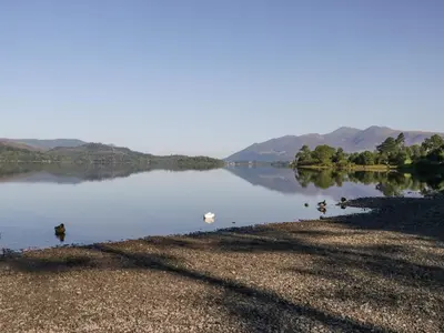 a lake with ducks swimming in the water at The Bothy in Keswick