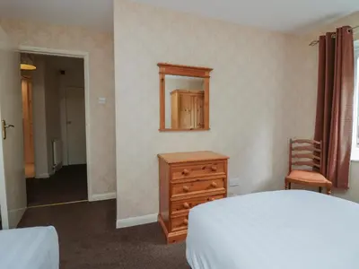 a bedroom with a bed and a dresser and a mirror at Apartment 2 in Keswick