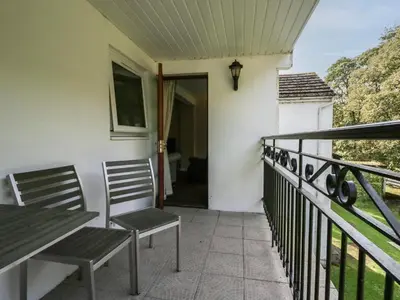 a porch with two chairs and a table on a balcony at Apartment 3 in Keswick