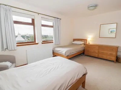 a bedroom with two beds and a window at Cairnhapple House in Stranraer