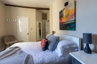 a bedroom with a bed and a painting on the wall at CastlegateTownhouse in Cockermouth