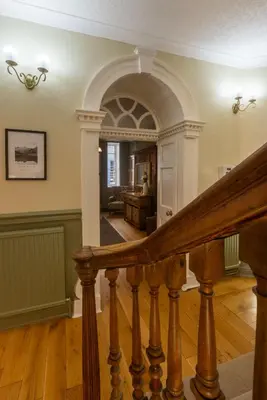 an entry hall with a staircase and an archway at CastlegateTownhouse in Cockermouth