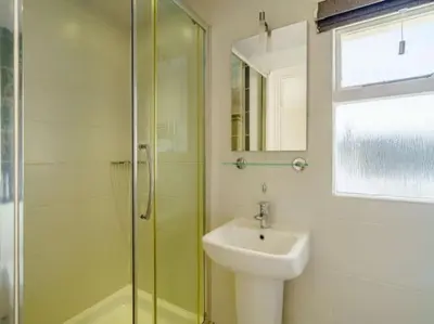 a bathroom with a sink and a glass shower at CastlegateTownhouse in Cockermouth